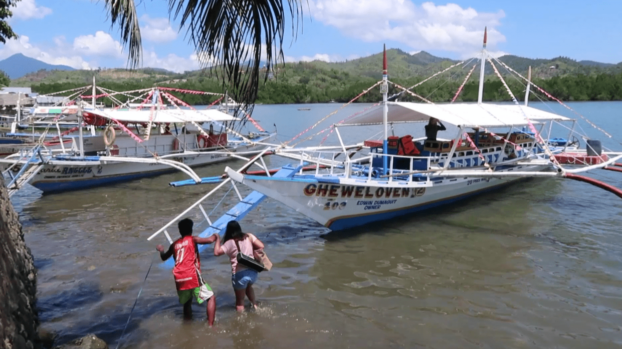 filipina girl stepping into boat in the philippines as part of the honda bay island hopping tour in puerto princesa palawan